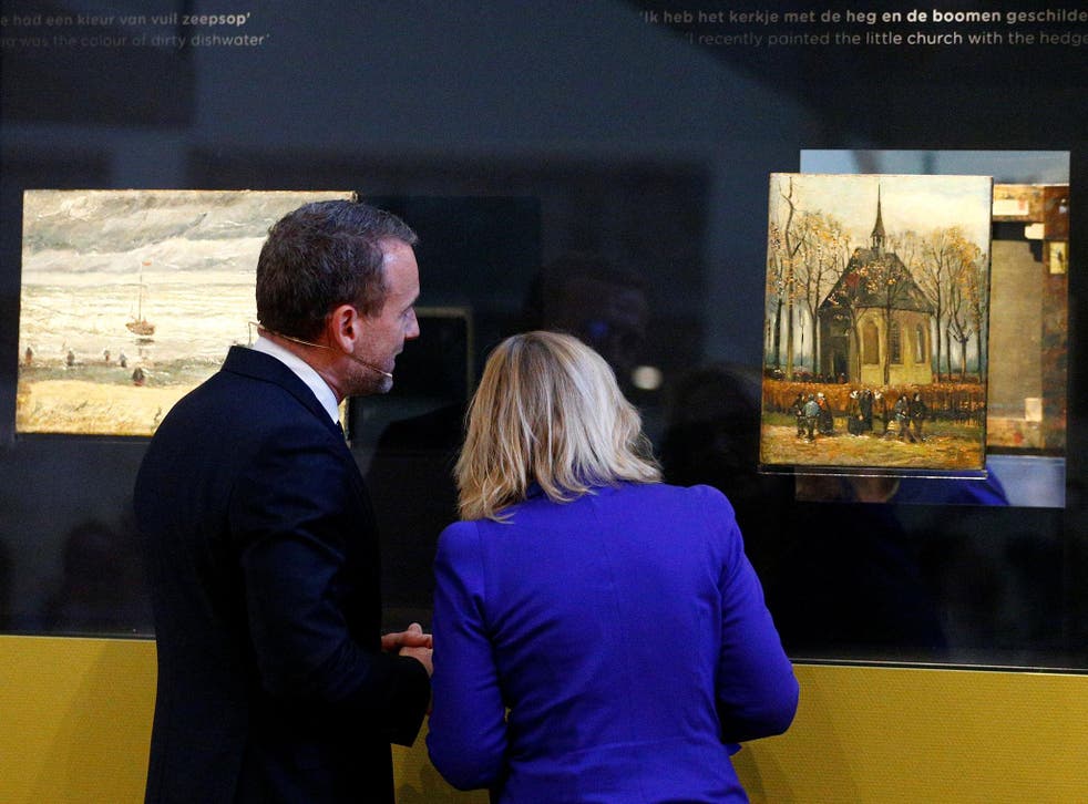 Museum director Axel Ruger and Dutch education minister Jet Bussemaker reveal two recovered paintings by Van Gogh