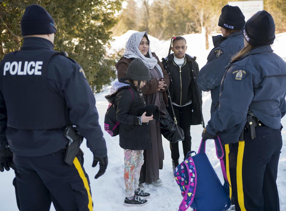 Royal Canadian Mounted Police officers arrest an asylum claimant and her two daughters after crossing the border into Canada from the United States