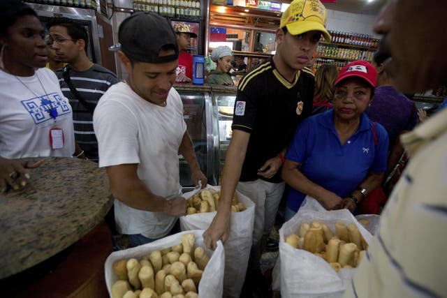 Employees of the Minka state-run bakery carry bags of cheap bread to be distributed to state-run grocery stores in Caracas