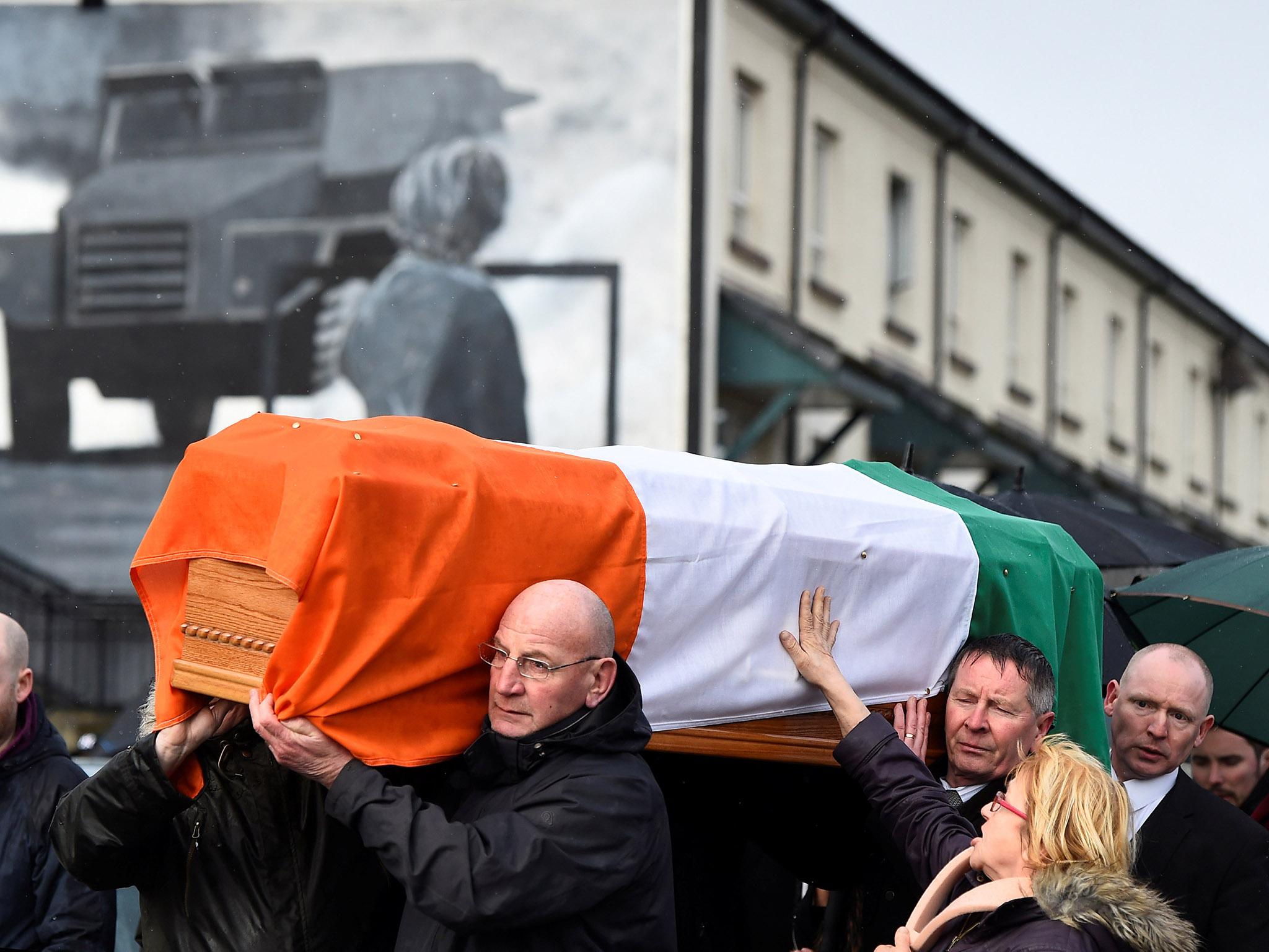 A woman touches the coffin of Martin McGuinness as it is carried through the streets of Derry, Northern Ireland