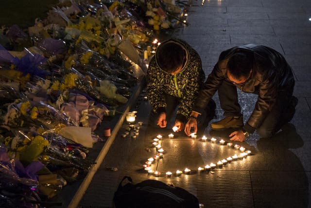 Mourners light candles in the shape of a heart at a makeshift memorial at the site of a stampede on 1 January, 2015