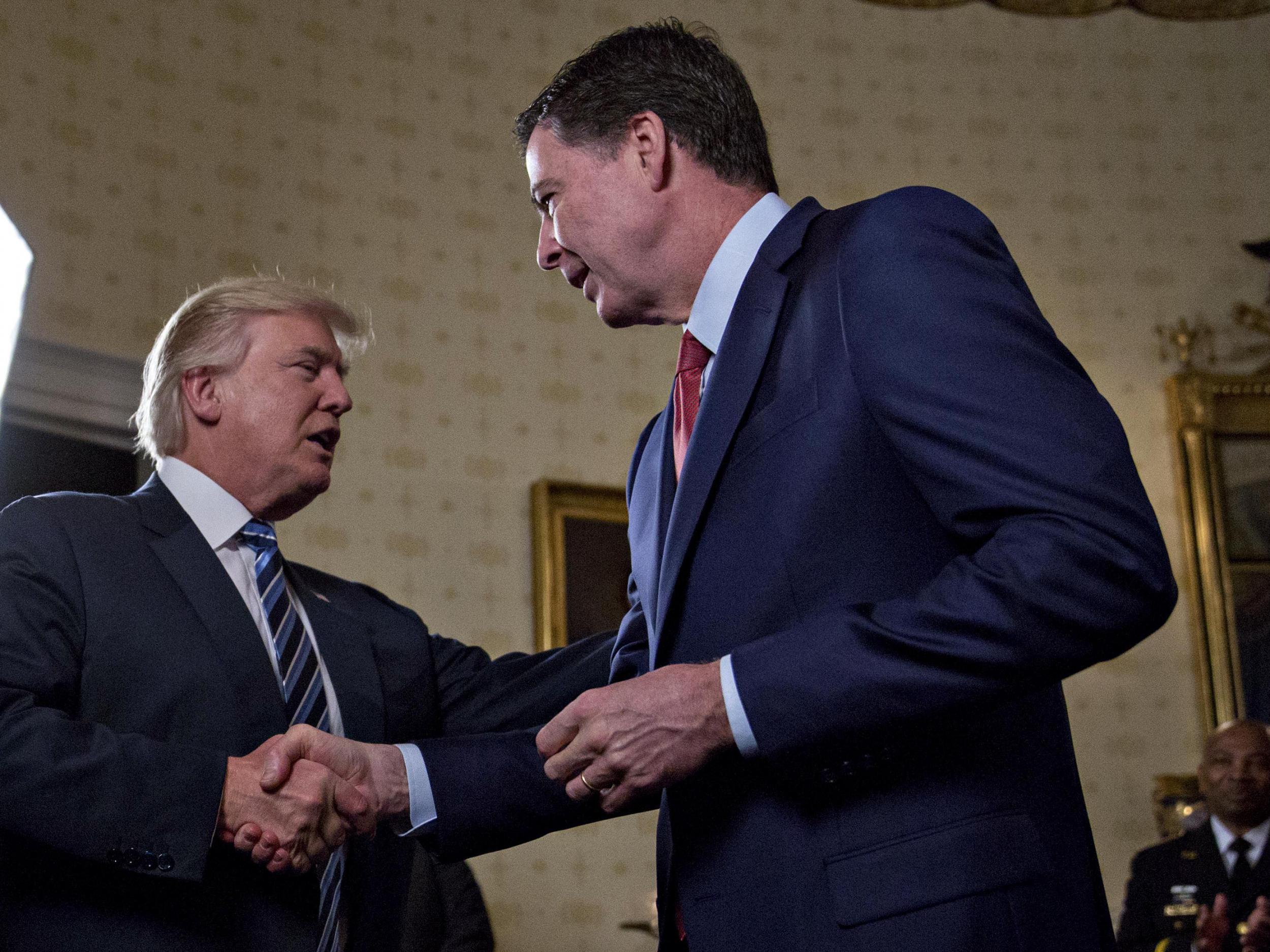 Donald Trump shakes hands with FBI director James Comey on 22 January 2017
