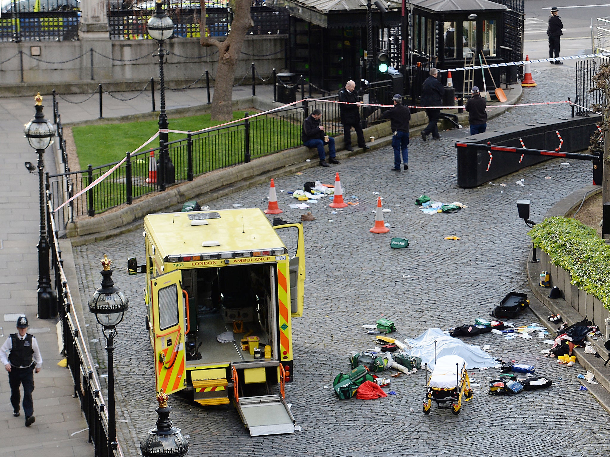 A body is covered by a sheet outside the Palace of Westminster, London, after a policeman was stabbed and his apparent attacker shot by officers in a major security incident at the Houses of Parliament