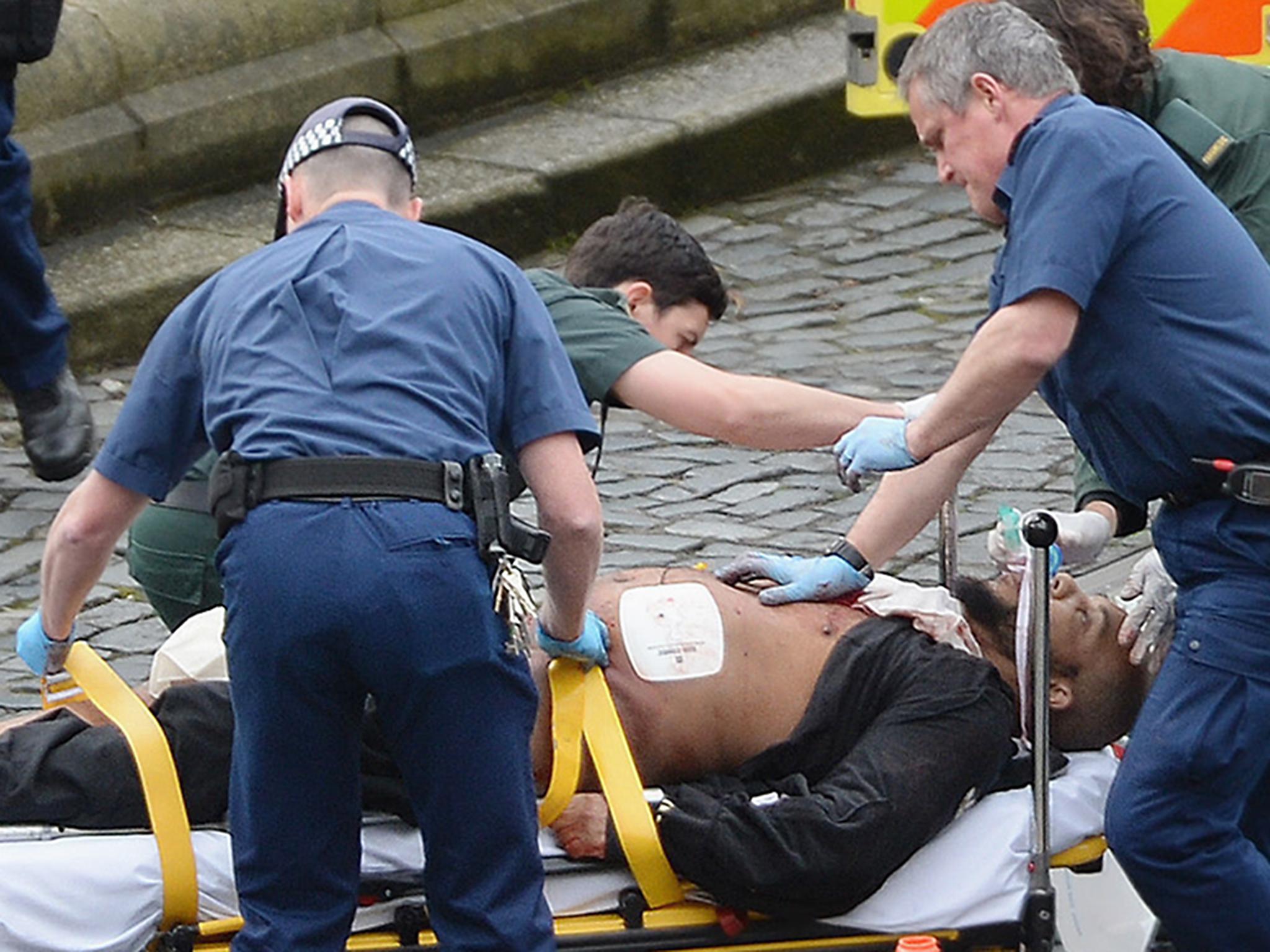 Emergency services at the scene in the immediate aftermath of the attack, as Masood is taken away in an ambulance