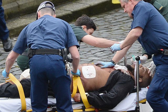 Emergency services assist Khalid Masood after he fatally stabbed policeman Keith Palmer before being shot to death