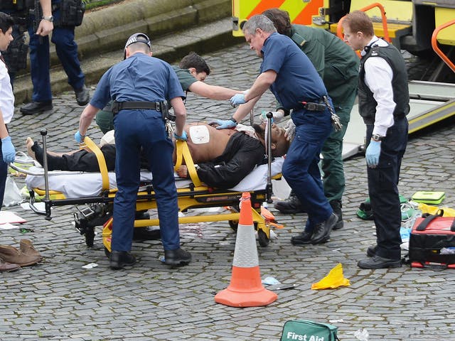  Emergency services at the scene in the immediate aftermath of the attack, as Masood is taken away in an ambulance