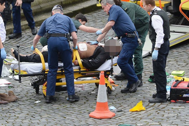 Emergency services treat an injured man after a police officer was stabbed and his apparent attacker was shot by officers at the Houses of Parliament