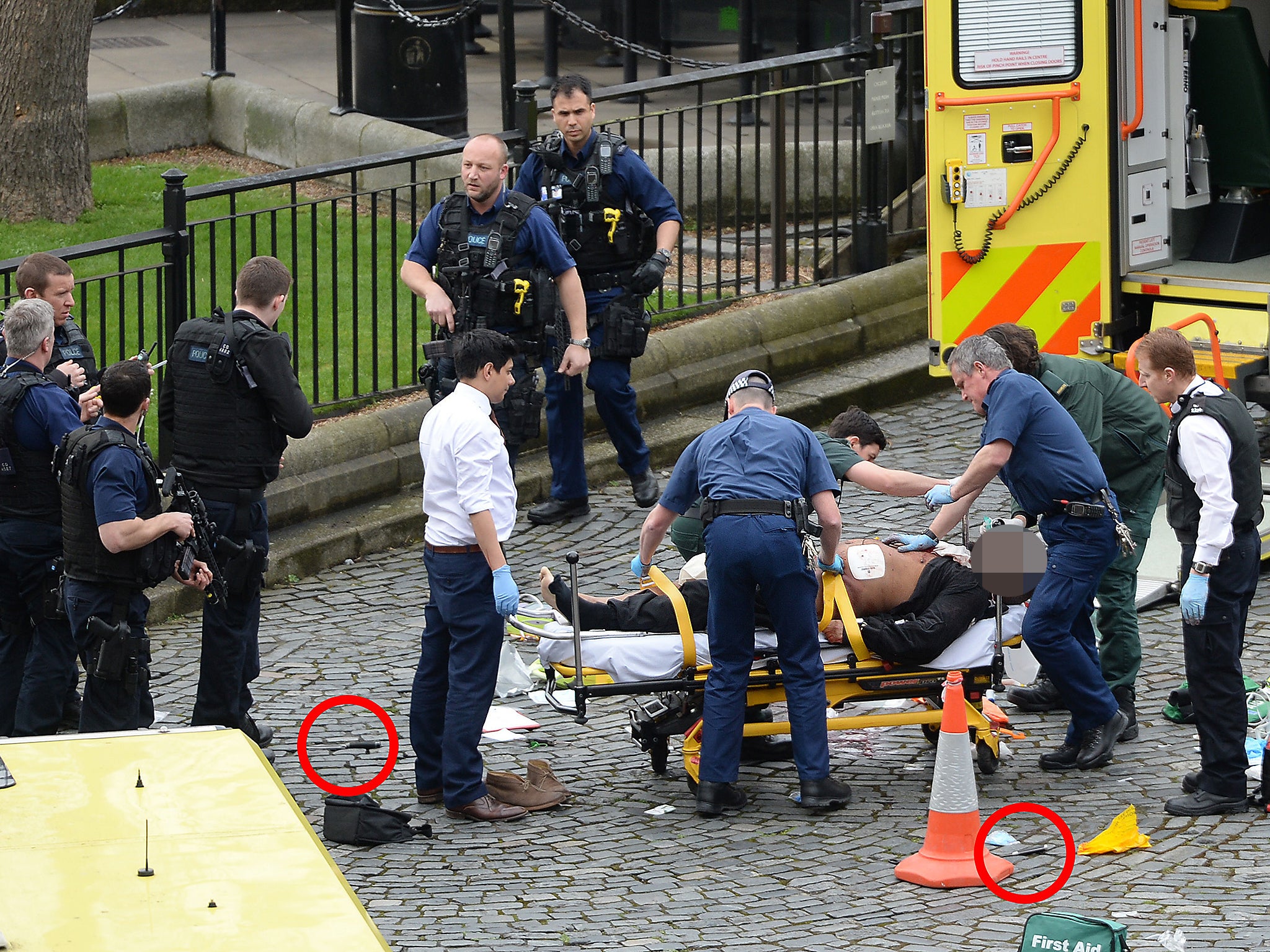 Two knives, circled in red, lay on the floor near the suspect