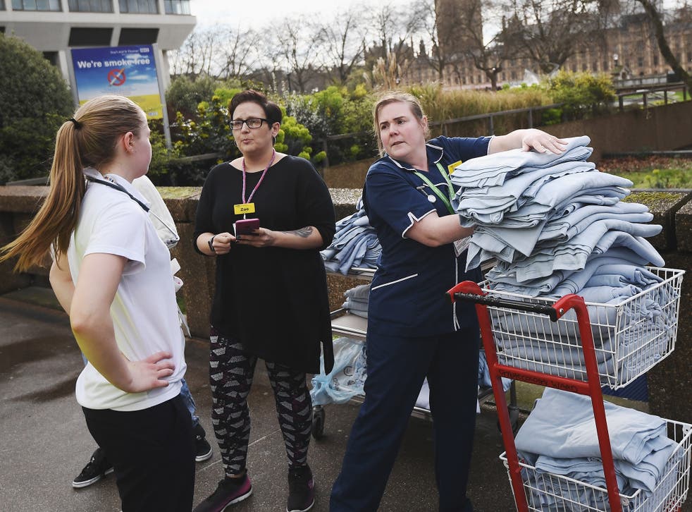 Nurses from St Thomas' hospital load blankets outside the hospital after a terrorist attack in Westminster