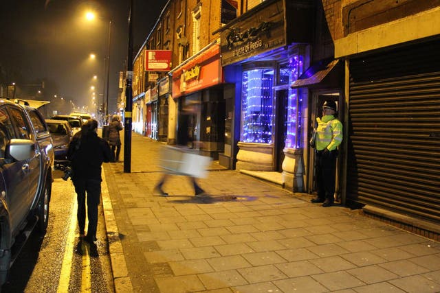 A police officer stand outside an address in Hagley Road, Birmingham, where armed police have raided a flat overnight