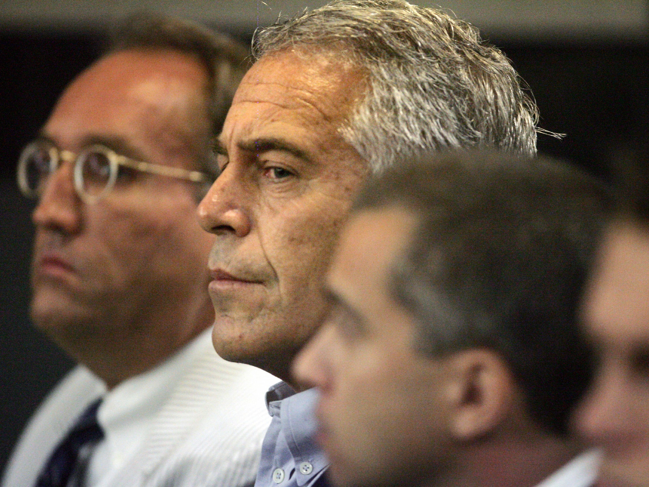 Jeffrey Epstein (centre) in custody in West Palm Beach, Florida, in 2008