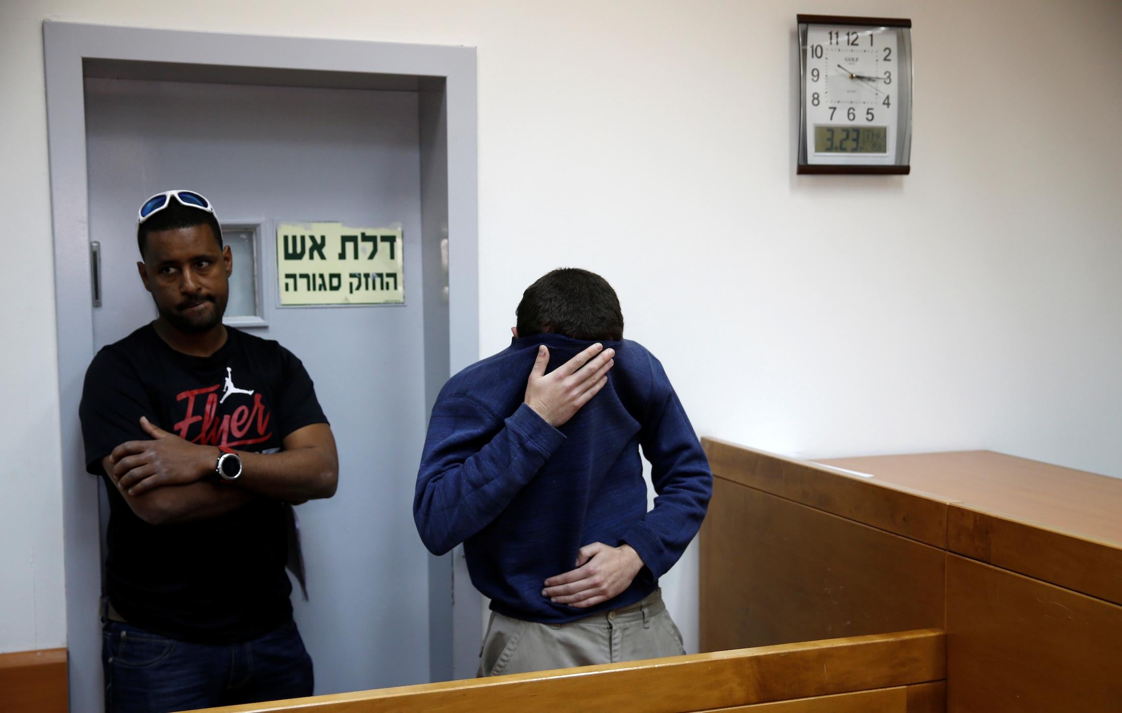 The teenager arrested on suspicion of making bomb threats against Jewish centres (right) attends a hearing in the Israeli city of Rishon LeZion on 23 March