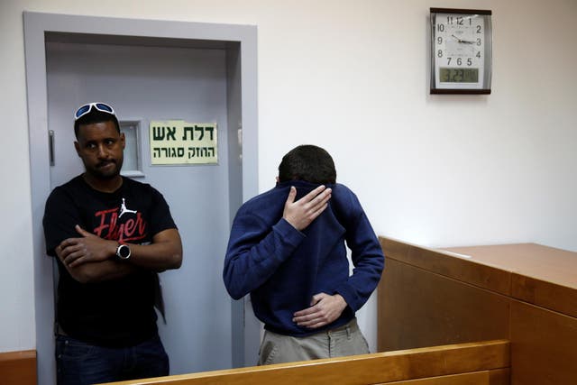 The teenager arrested on suspicion of making bomb threats against Jewish centres (right) attends a hearing in the Israeli city of Rishon LeZion on 23 March
