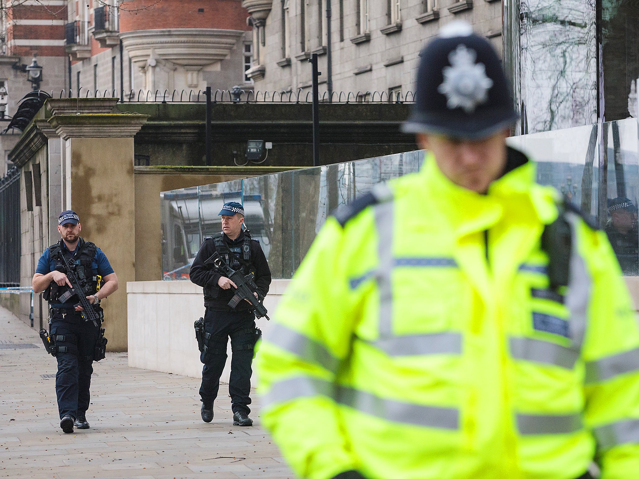 Armed police officers patrol outside New Scotland Yard following yesterday's attack in London