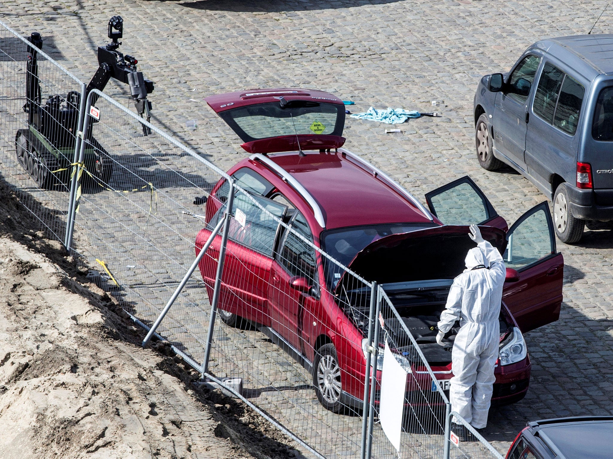A forensics expert stands next to a car which entered the main pedestrian shopping street in Antwerp