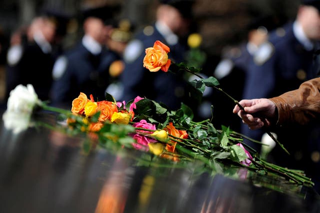 A family member lays a flower at a commemoration ceremony at the National September 11 Memorial & Museum at the World Trade Center site in Manhattan