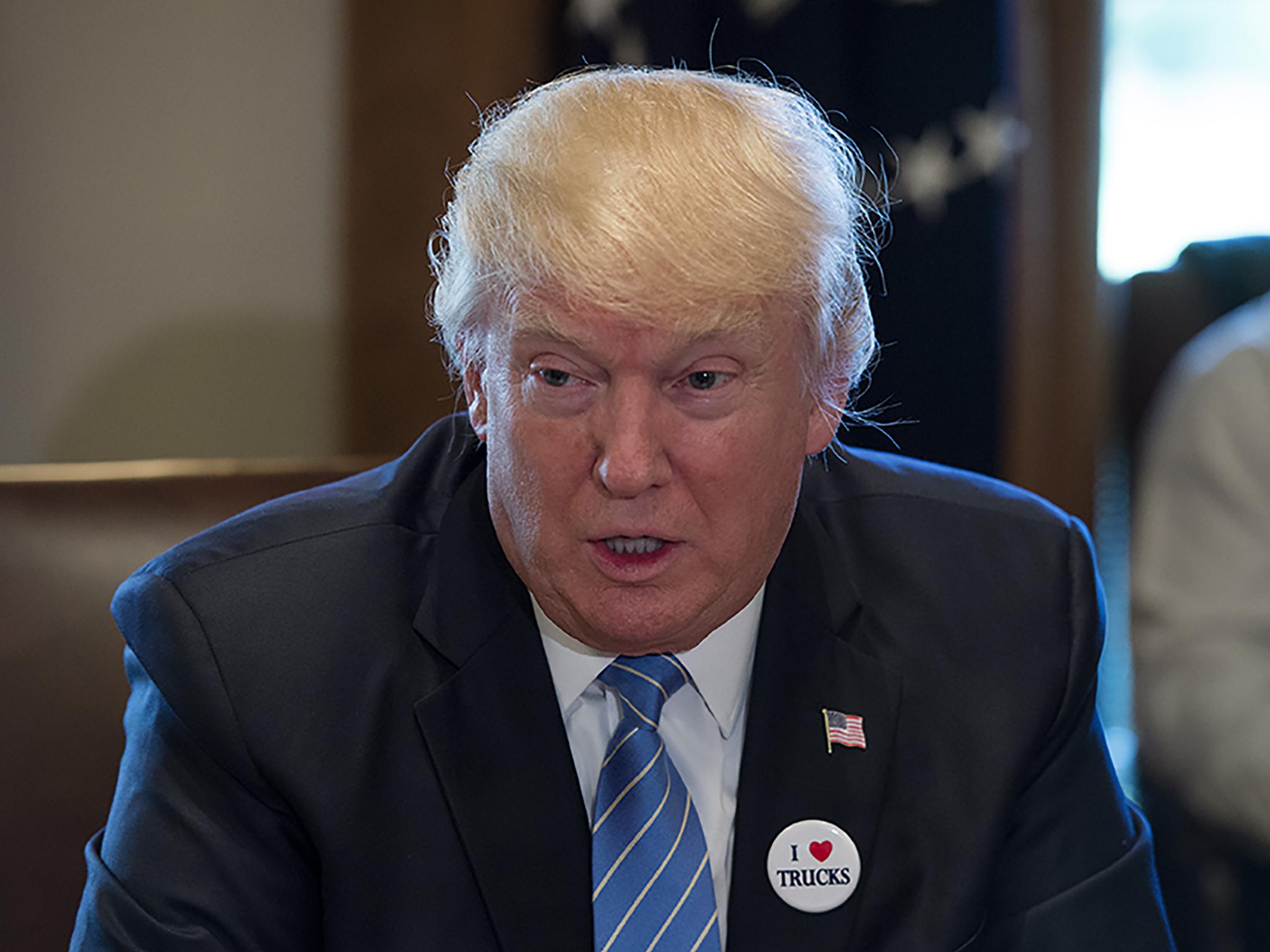 Mr Trump sported an ‘I love trucks’ badge while meeting with truckers and CEOs to hear out their health care concerns (Getty)