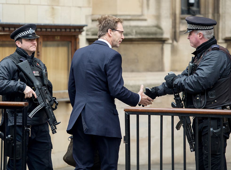Tobias Ellwood MP shakes hands with an armed policeman as he arrives at the Houses of Parliament 