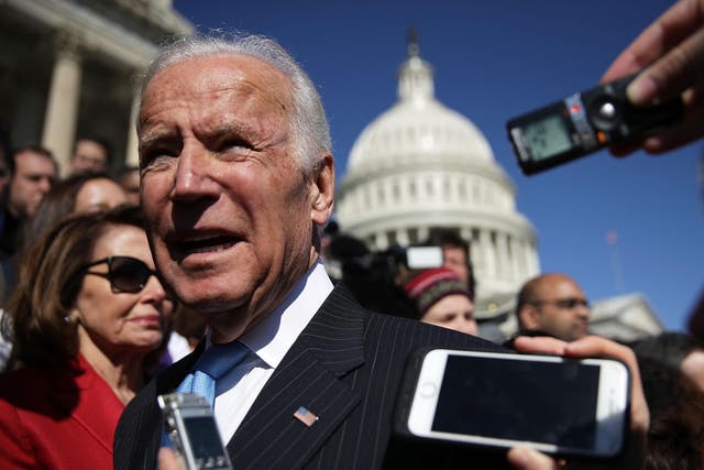 Joe Biden speak to journalists at a protest against the dismantling of Obamacare