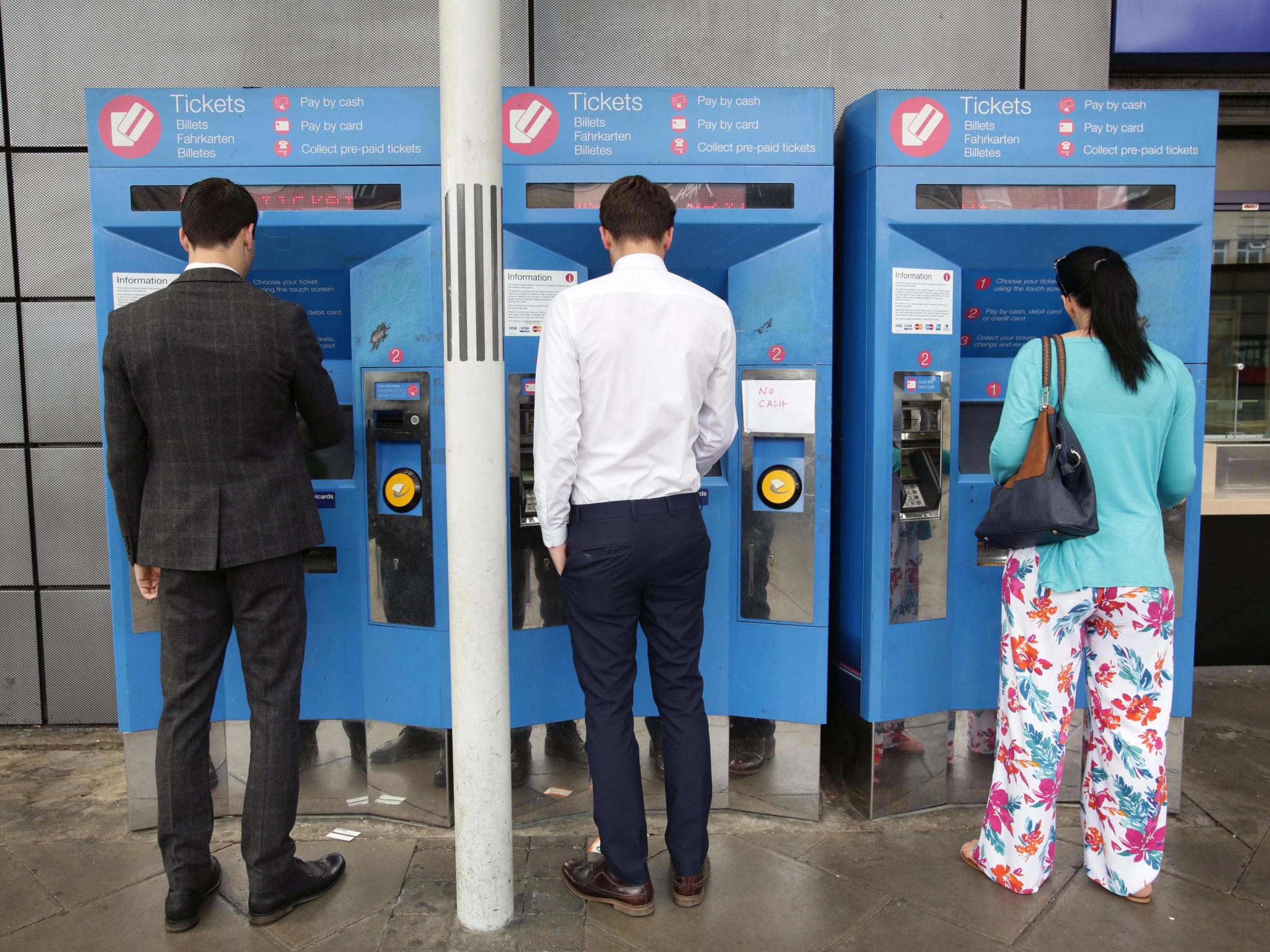 Commuters buy train tickets from machines at Finsbury Park station in north London