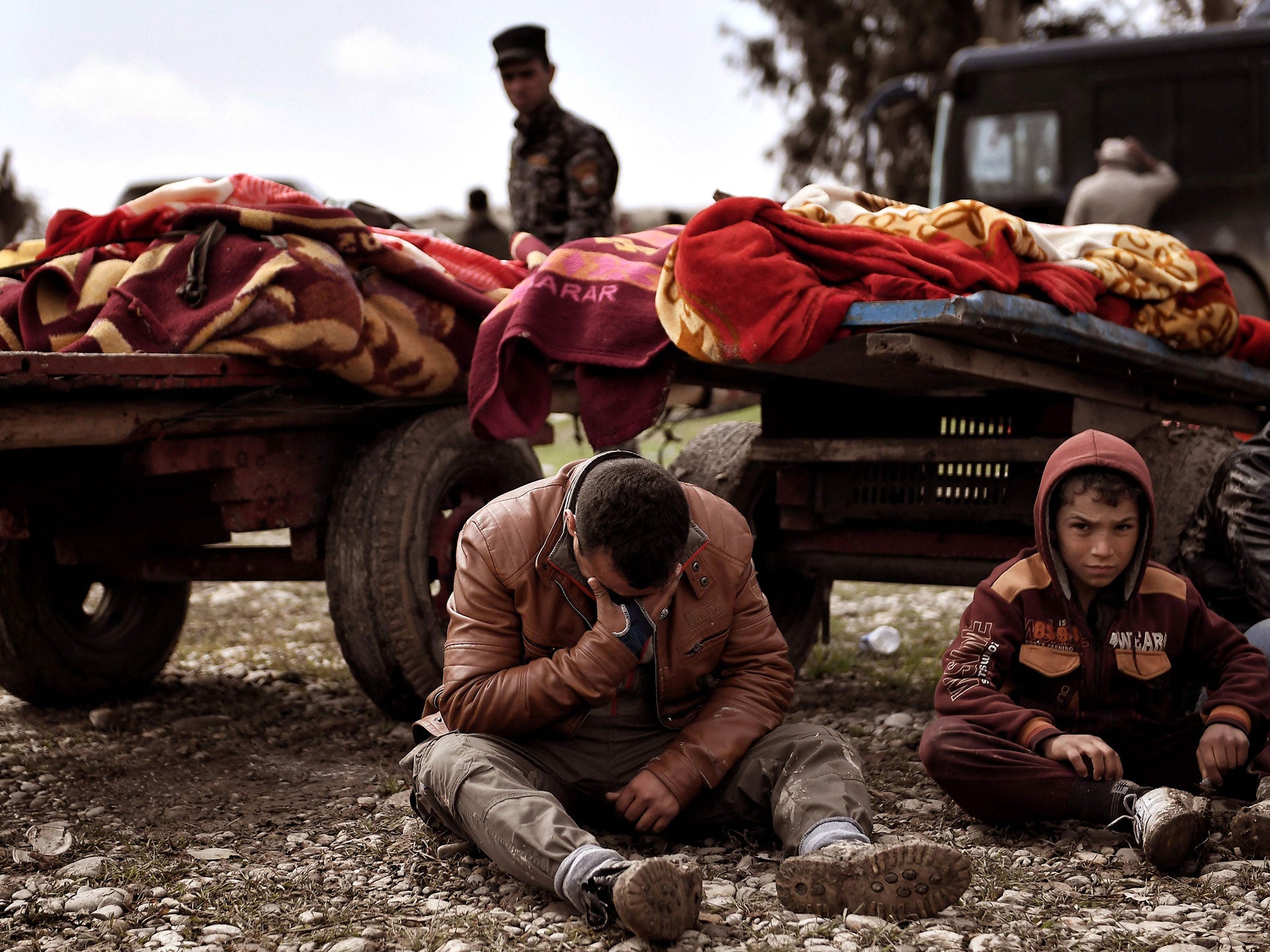 Relatives mourn next to bodies of Iraqi residents of west Mosul killed in an air strike targeting Isis on 17 March 2017