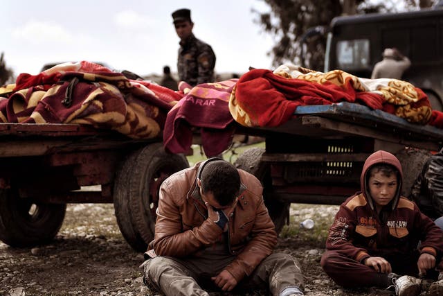 Relatives mourn next to bodies after residents after an air strike in Mosul in March