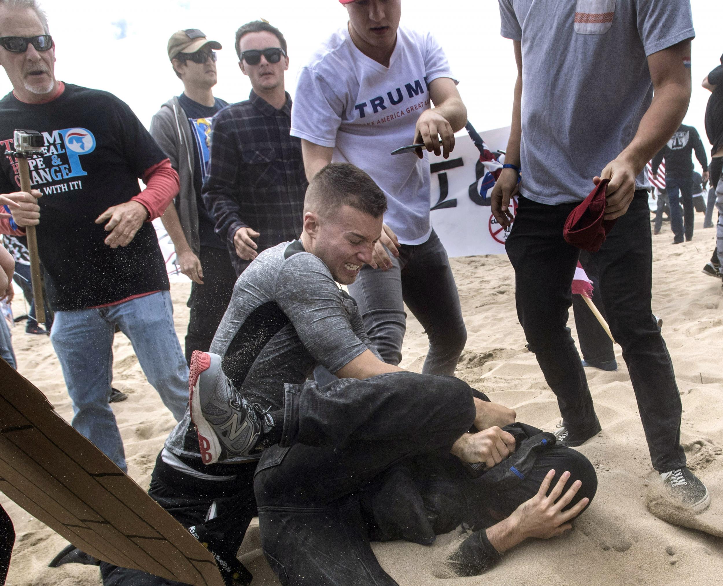 A supporter of Donald Trump, centre, clashes with an anti-Trump protester