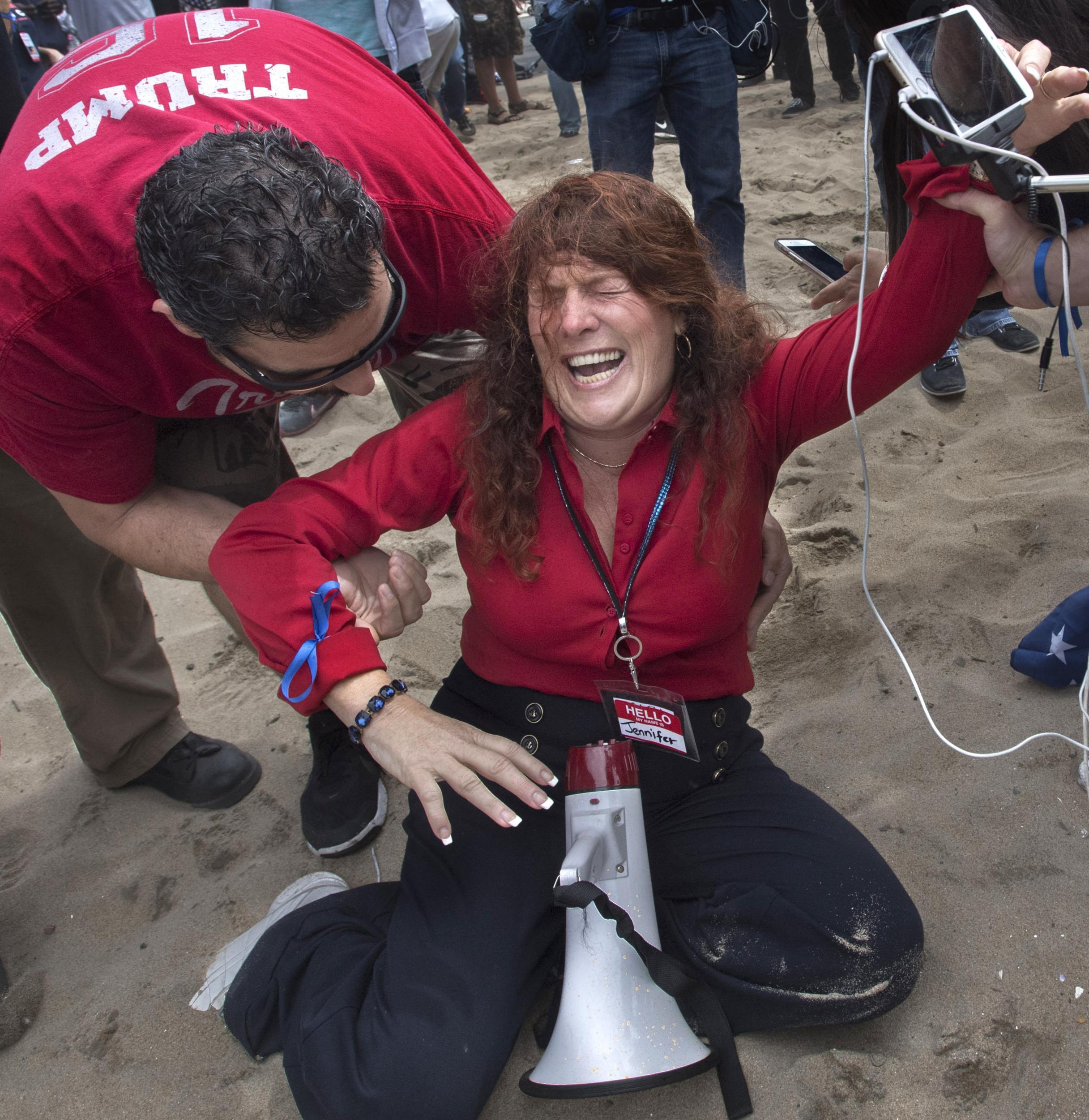 Jennifer Sterling, one of the organisers of the pro-Donald Trump rally reacts after getting hit with pepper spray