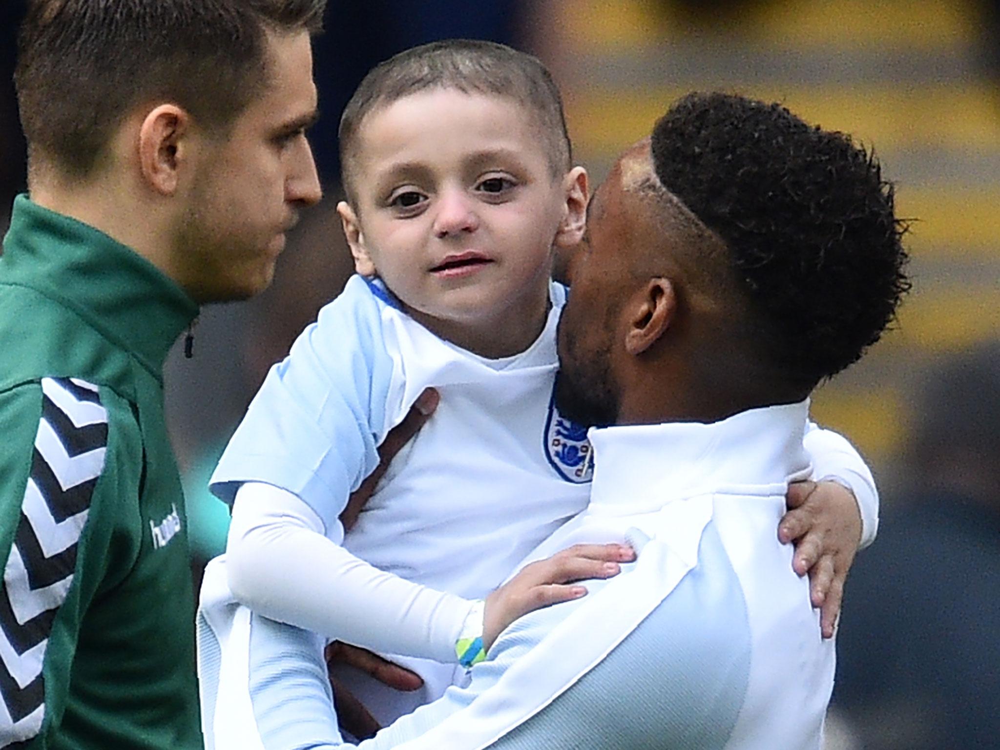 England's striker Jermain Defoe (R) holds Bradley Lowery, a five-year-old suffering from terminal cancer, mascot for the match, ahead of the World Cup 2018 qualification football match between England and Lithuania at Wembley