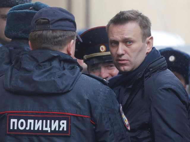 Russian opposition leader Alexei Navalny is escorted to a court hearing after being detained at the protests