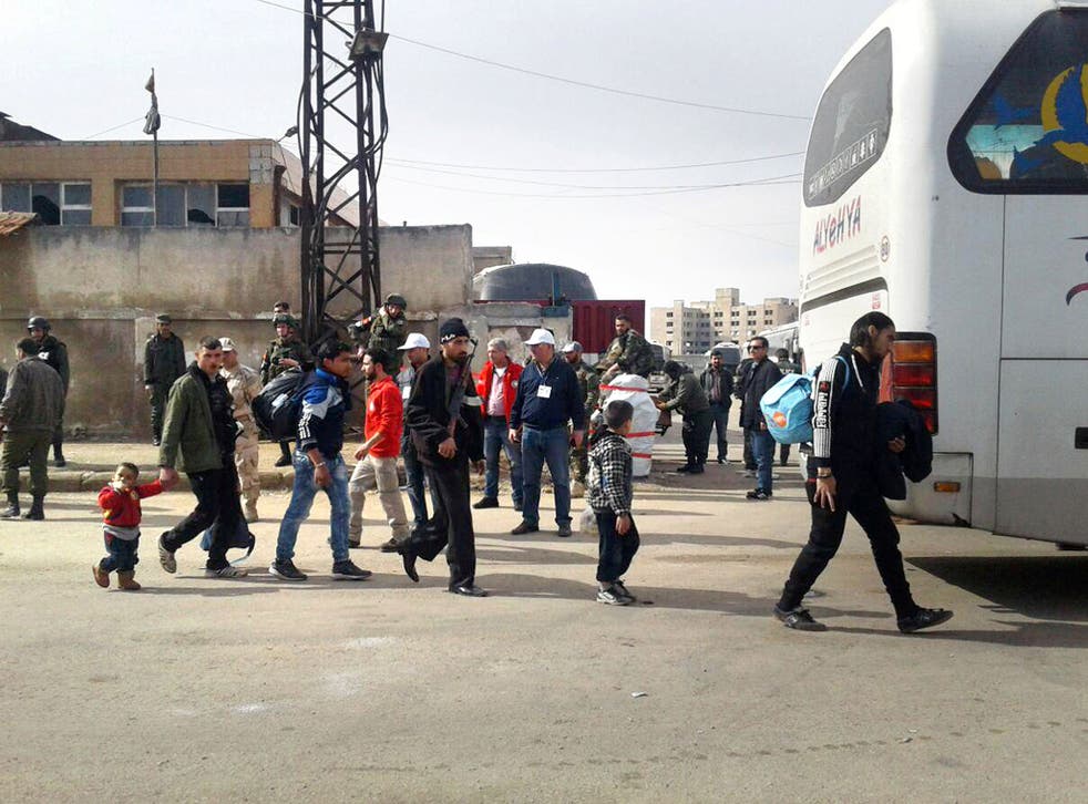With guns and few possessions rebel fighters and their families evacuate the al-Wa'er district in the central Syrian city of Homs