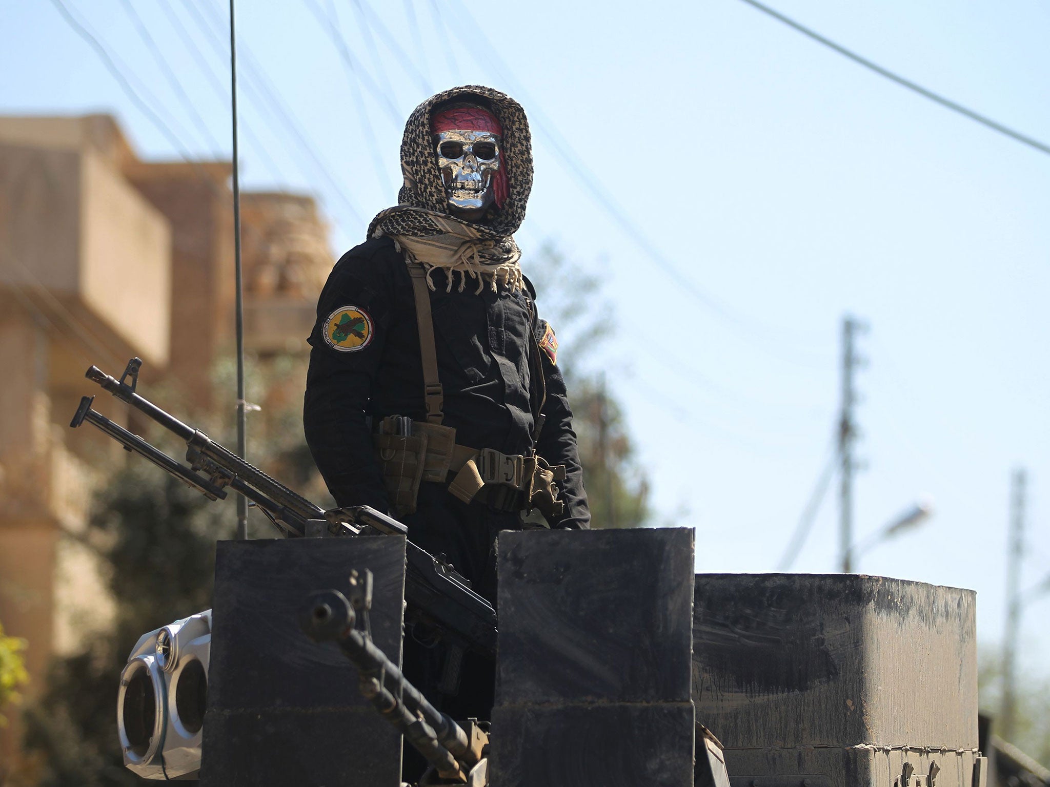 An Iraqi soldier stands guard in Mosul's al-Jadida area, where air strikes have killed a large number of civilians in recent days