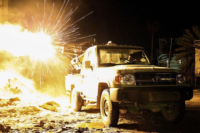A member of the Libyan National Army (LNA) fires a machine gun mounted on the back of a Toyota pickup truck against jihadists in district of Suq al-Hut in the eastern coastal city of Benghazi