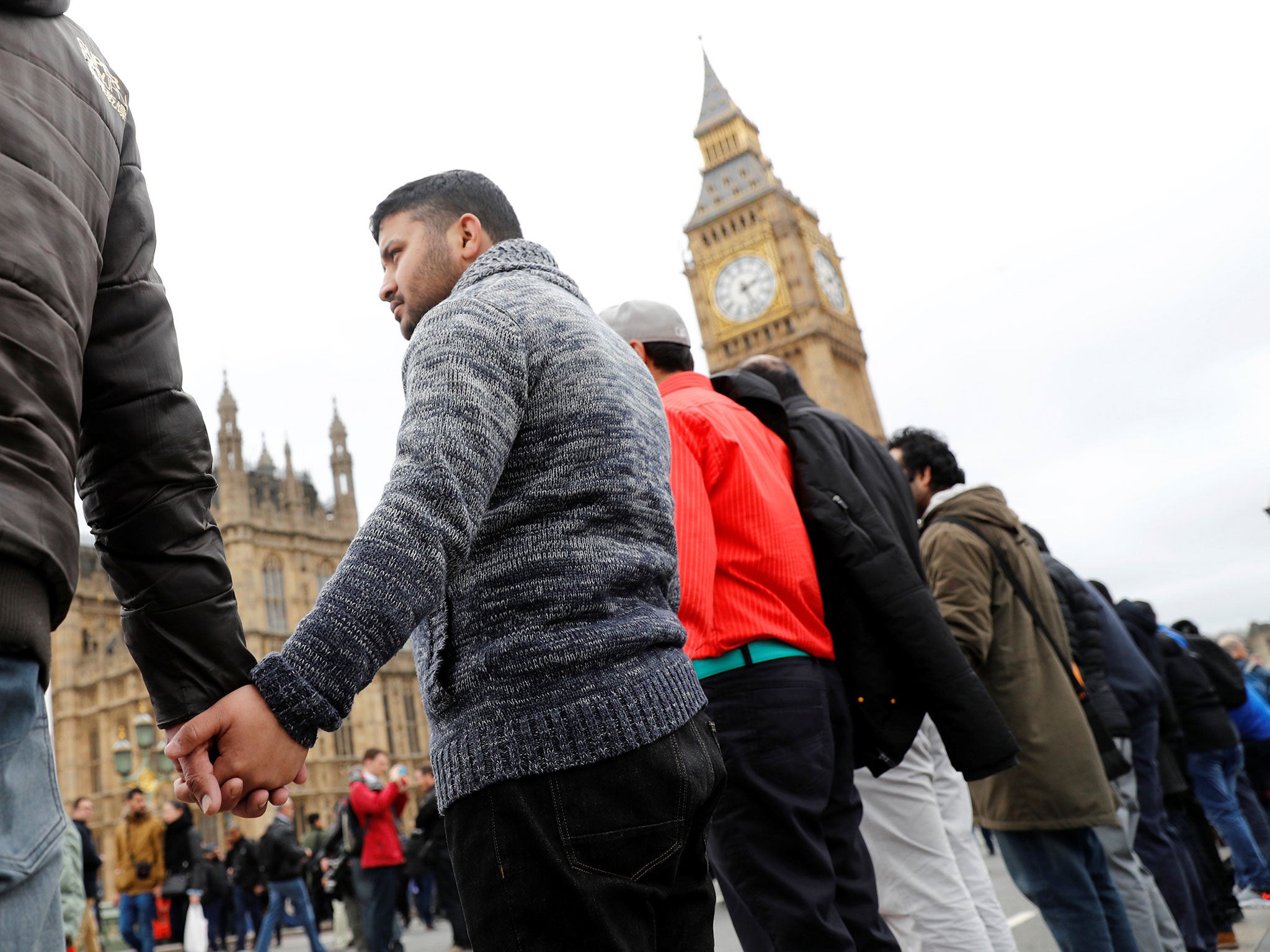 People hold hands on Westminster Bridge during an event to mark one week since the Westminster attack on 29 March