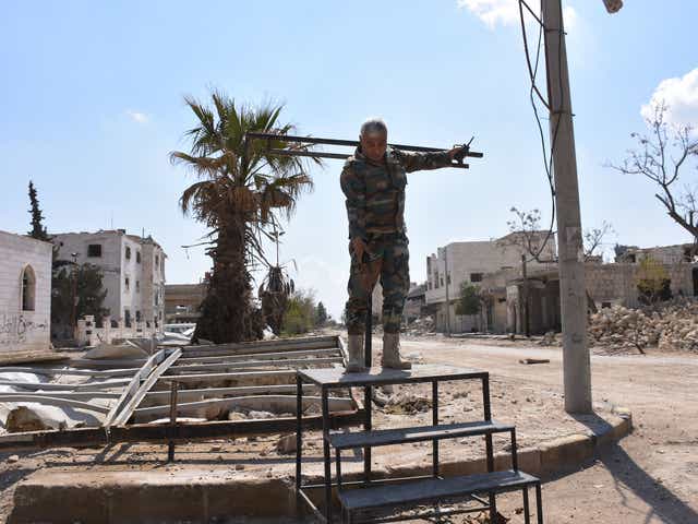 A Syrian soldier demonstrates how the crucifixion stand erected and used by Isis works