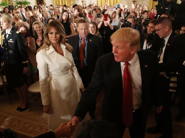 US President Donald Trump and first lady Melania Trump walk away after attending an event celebrating Women's History Month