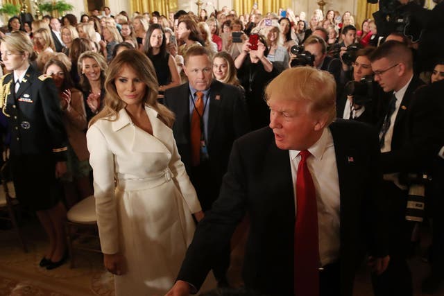 US President Donald Trump and first lady Melania Trump walk away after attending an event celebrating Women's History Month