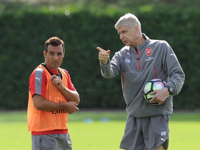 Arsene Wenger the Manager of Arsenal chats to Santi Cazorla of Arsenal during Arsenal Training Session