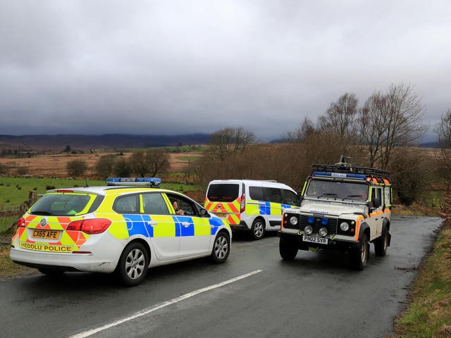 A South Snowdonia Mountain Rescue 4x4 passes two North Wales Police cars that have closed the road in Trawsfynydd, North Wales