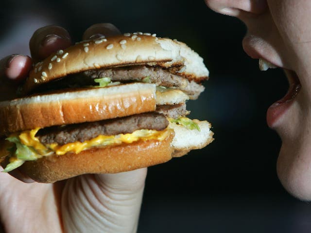 A woman eats a beefburger