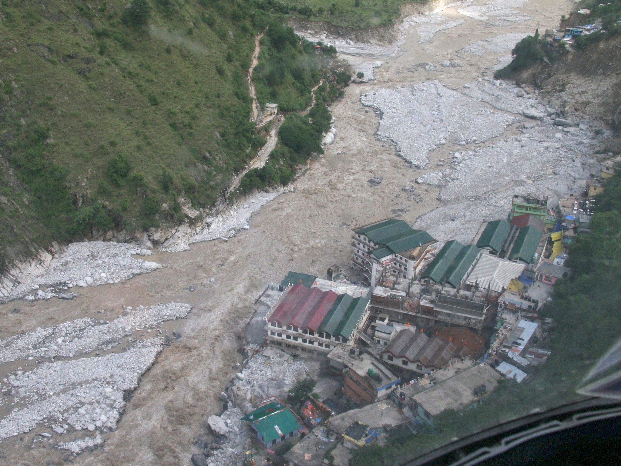 Flood waters flow next to a residential complex during major floods in the Himalayan state of Uttarakhand in 2013