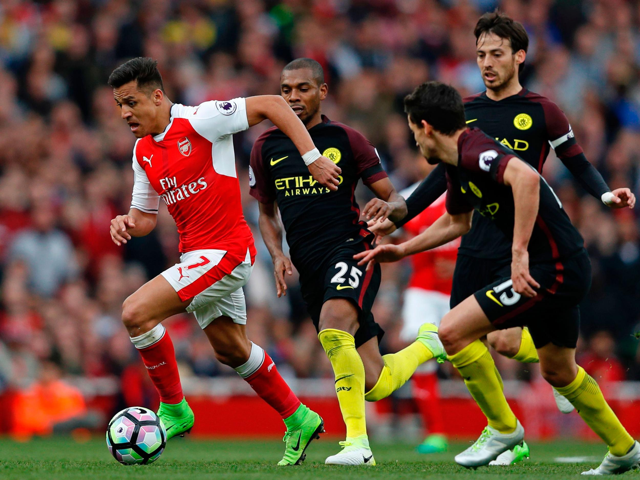 Alexis Sanchez carries the ball forward past Manchester City's midfield