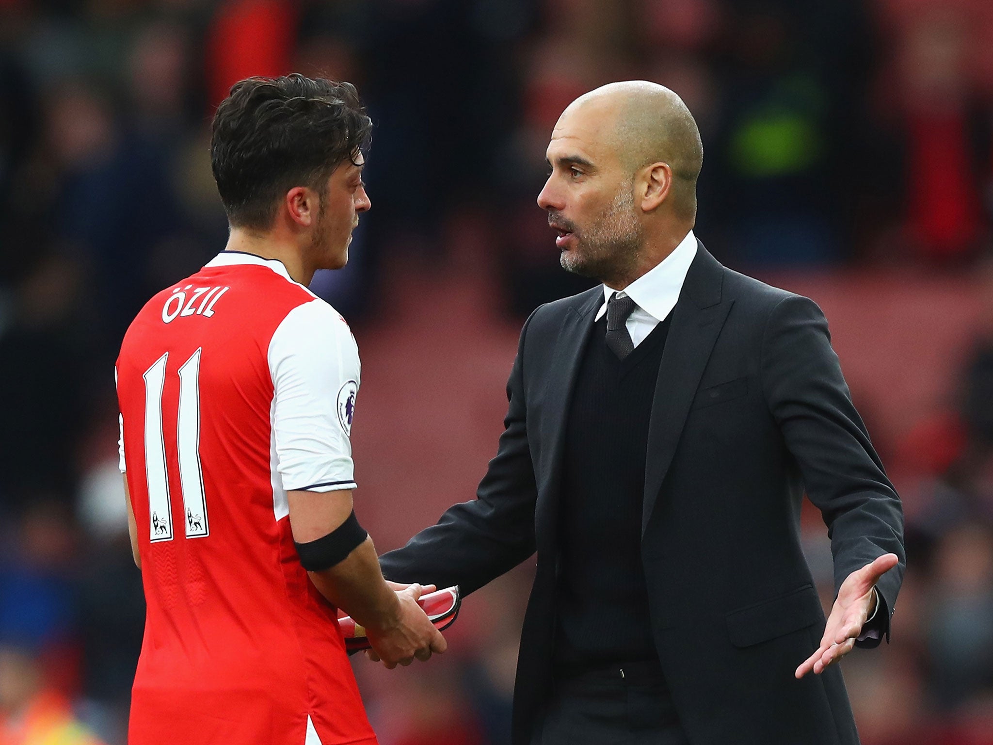 Pep Guardiola speaks to Mesut Ozil after the final whistle