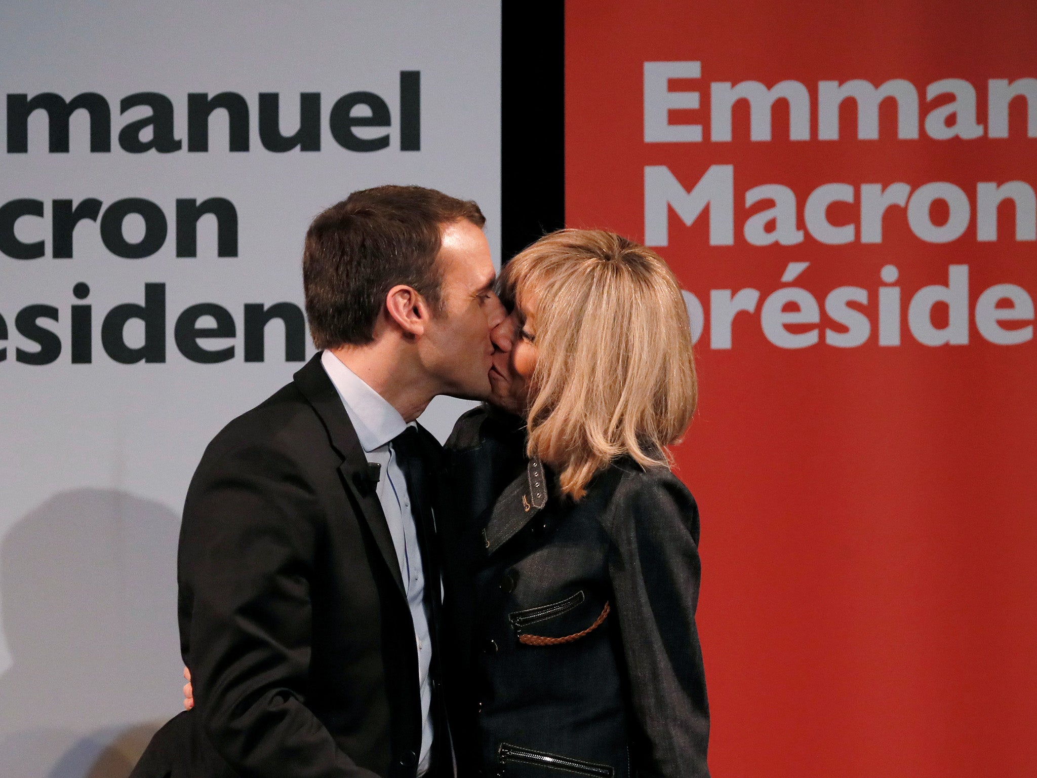 Emmanuel Macron kisses his wife Brigitte at a campaign rally