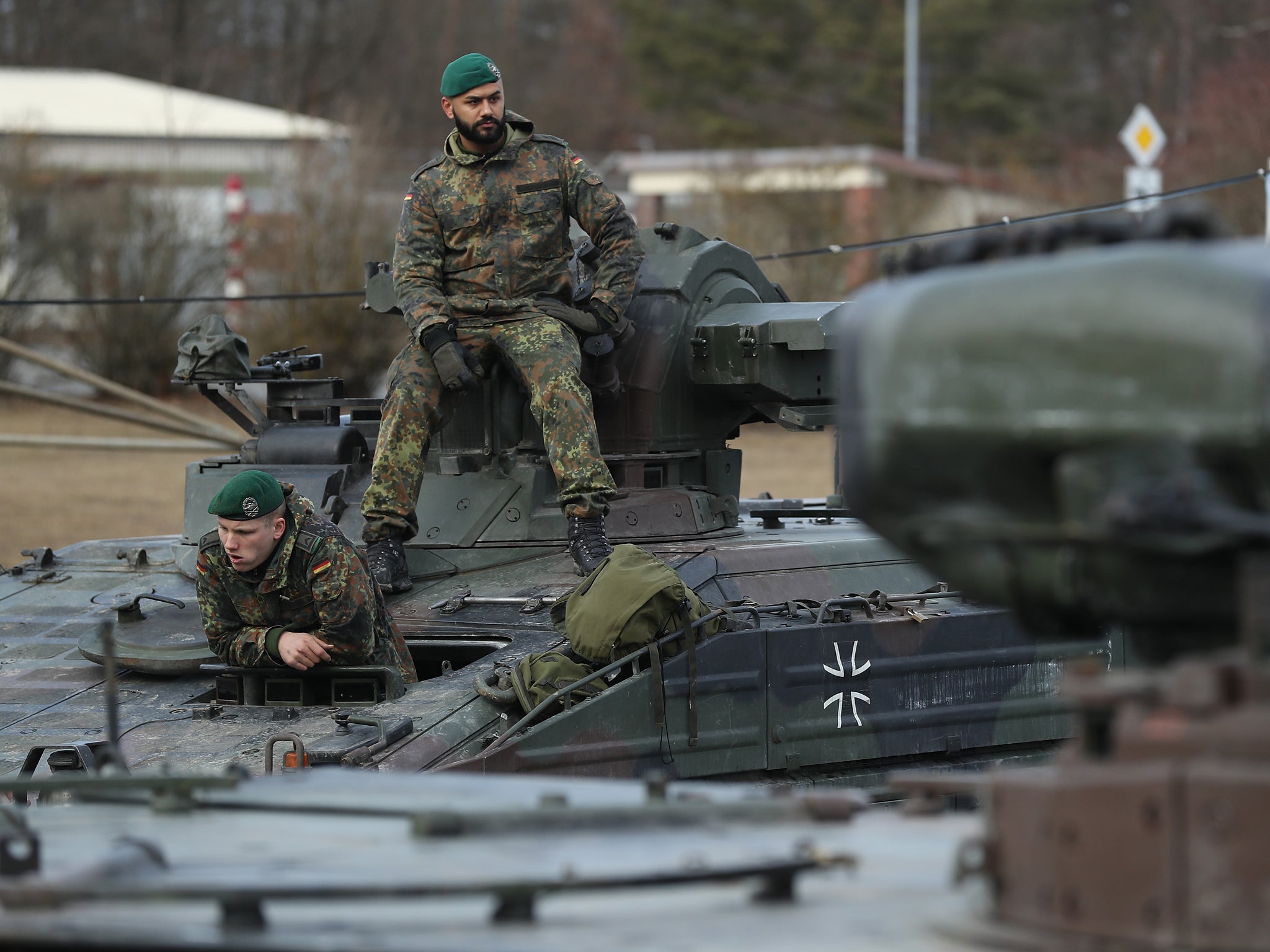 Soldiers of the Bundeswehr, the German armed forces, prepare to drive Marder light tanks onto a train for transport to Lithuania
