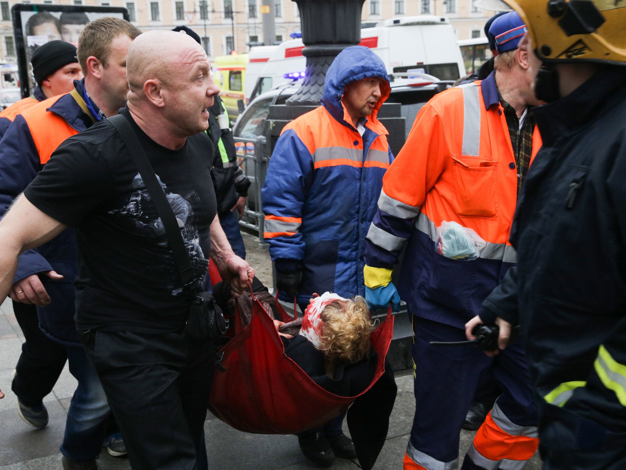 Emergency workers carry an injured person at the entrance to a St Petersburg metro station in the aftermath of Monday's explosion