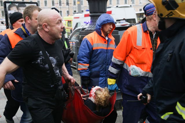 Emergency workers carry an injured person at the entrance to a St Petersburg metro station in the aftermath of Monday's explosion