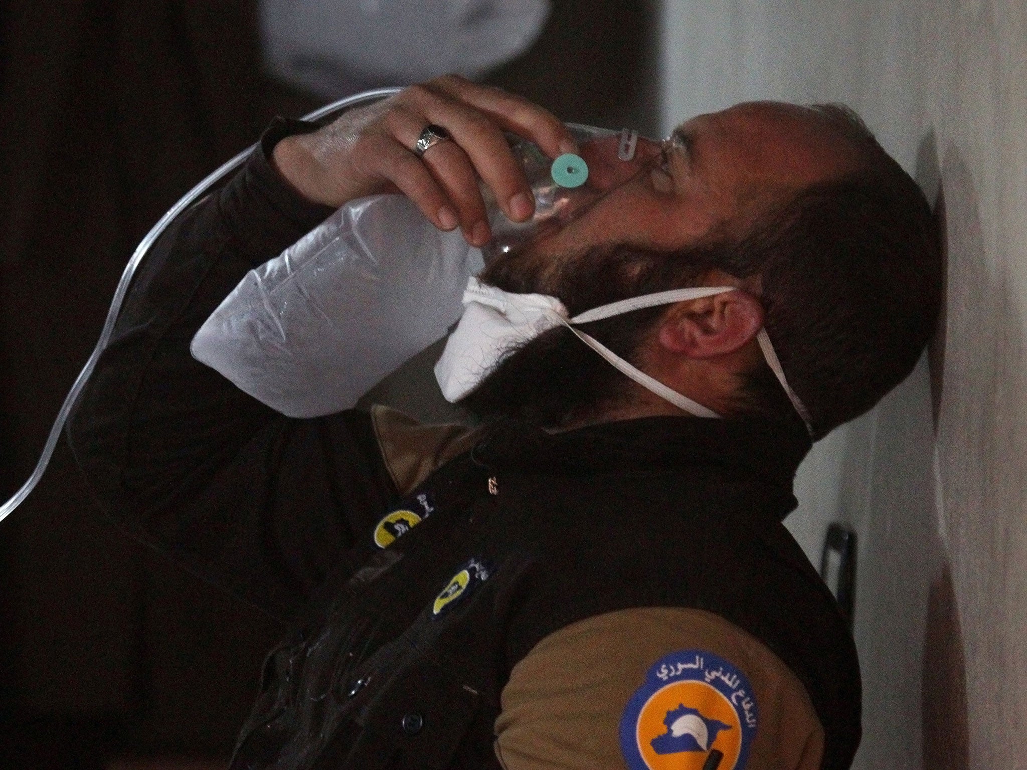 A White Helmets rescuer breathes through an oxygen mask, after a suspected gas attack in the town of Khan Sheikhoun, Idlib, on 4 April