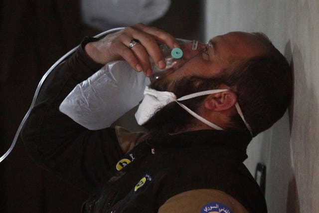 A White Helmets rescuer breathes through an oxygen mask, after a suspected gas attack on Idlib province in April