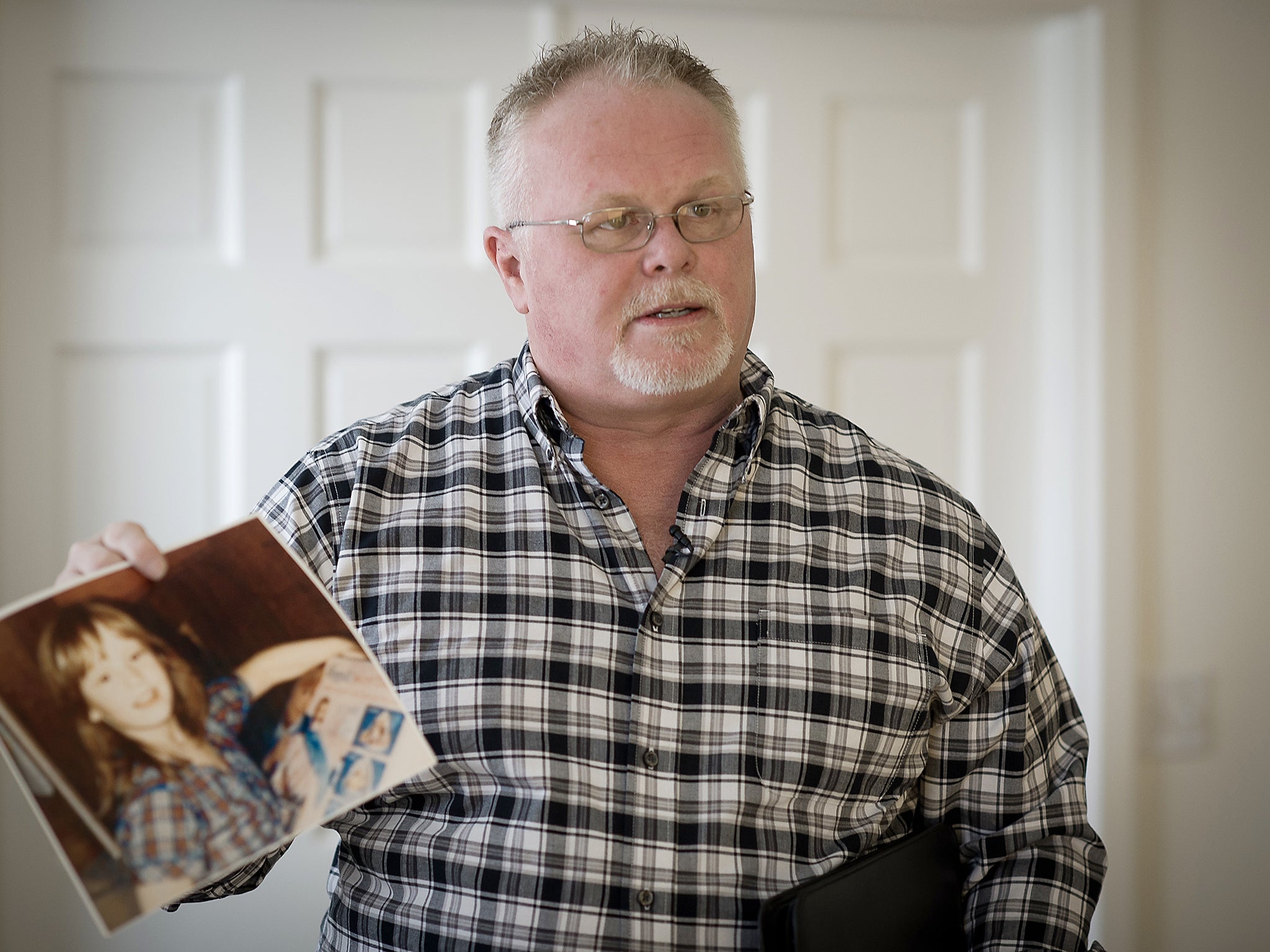 Keith Bloodsworth, a former US marine, with a picture of the nine-year-old Maryland girl for whose rape and murder he spent nine years on death row. DNA evidence eventually proved his innocence, which he had always maintained (Getty)